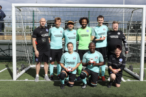 The Brighton and Hove Albion Blind FC squad and their coaches posing with their medals after the FA Cup Blind Final