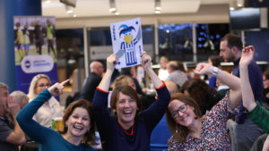 people celebrating at a table in a quiz night